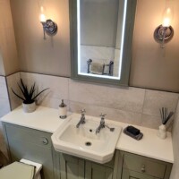 Traditional fitted furniture featuring solid surface, with LED mirror and wall lights