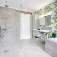 Disabled wet room featuring bespoke tiled shower seat with digital shower, wheelchair-accessible shower space and bespoke basin