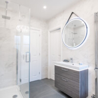 Dansani wall-hung basin unit with LED lighting, LED mirror, chrome finished radiator with towel bar, frameless shower enclosure and concealed smart shower