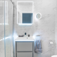 LED basin unit with lighting, LED mirror cabinet, frameless shower door and marble effect tiles