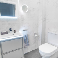Close coupled toilet, wall-hung basin unit with LED lighting and marble effect tiles