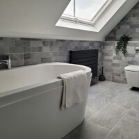 Bathroom with a vaulted ceiling featuring a wall-hung pan and free-standing back-to-wall bath