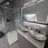 Walk-in shower with linear waste, his and hers basin unit with LED mirror cabinet and decorative tiling