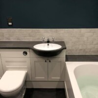 Traditional fitted furniture with coloured all-in-one basin and brick effect tiling